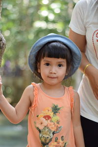 Portrait of girl standing with mother in forest