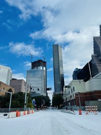 Street amidst buildings in city against sky