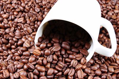 Close-up of roasted coffee beans with cup