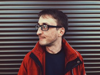 Portrait of young man standing against wall