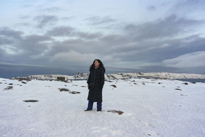 Rear view of woman standing on snow covered landscape