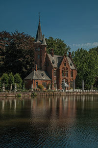 Lake with trees and old brick building in bruges. a town full of canals in belgium.