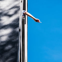 Low section of man against blue sky