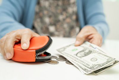 Midsection of man holding paper currency