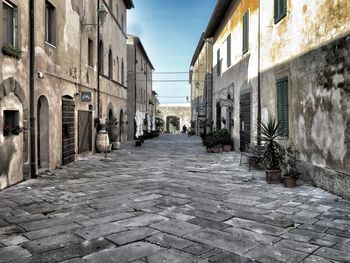 Walkway amidst buildings against sky