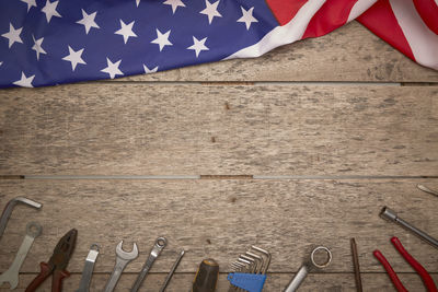 Directly above shot of american flag and work tools on wooden table