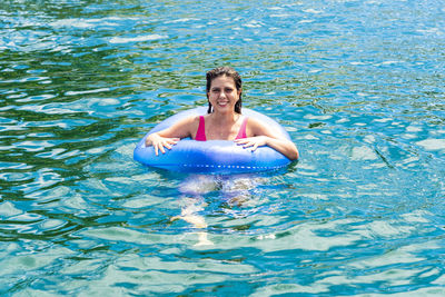 Woman in a bikini in the sea water with a buoy. 