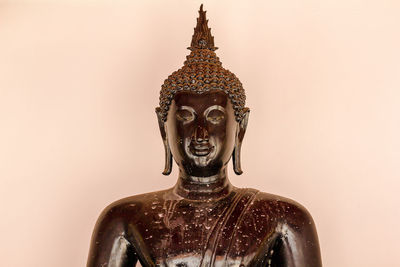 Close-up of buddha statue against gray background