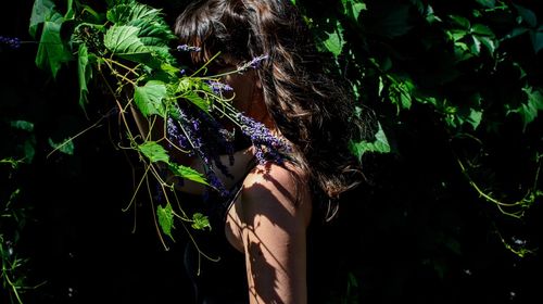 Rear view of woman standing by plants