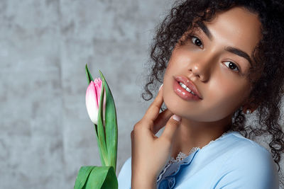 Portrait of beautiful woman against wall