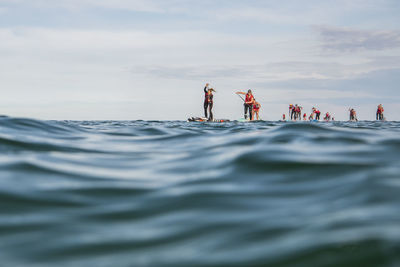 People paddleboarding in sea