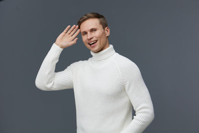 Portrait of young woman standing against black background