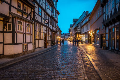 Street amidst buildings in city at night