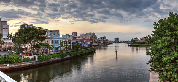 River amidst buildings in city against sky