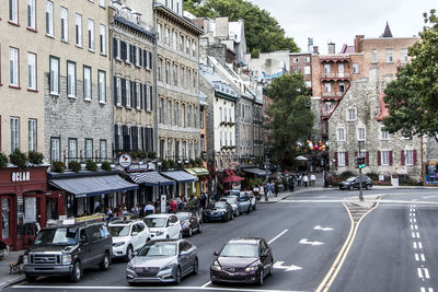 Vehicles on road by buildings in city