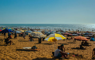 Group of people on beach against sky