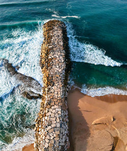 Aerial view from a stone jetty. stone wave breaker blocks to protect the coast from erosion