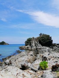 Rock formation on beach against sky