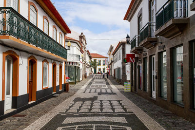 Footpath amidst buildings in city