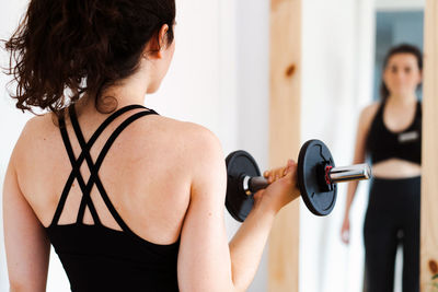 Side view of woman exercising at gym