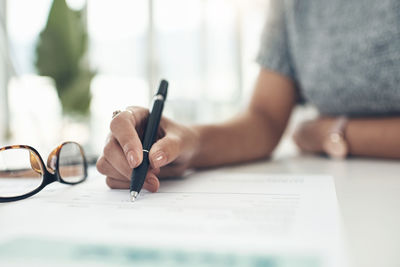 Midsection of woman doing paperwork