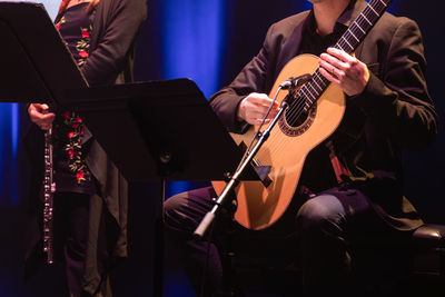 Midsection of man playing guitar