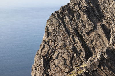 Rock formation in sea against sky