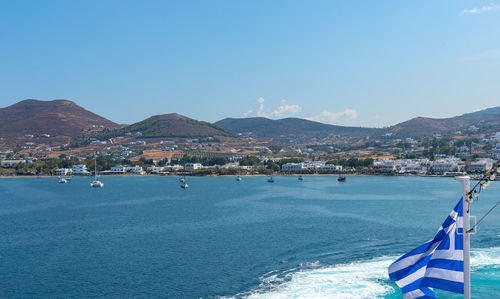 Scenic view of sea by buildings against blue sky