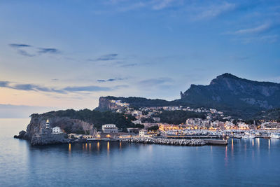 Scenic view of sea by townscape against sky