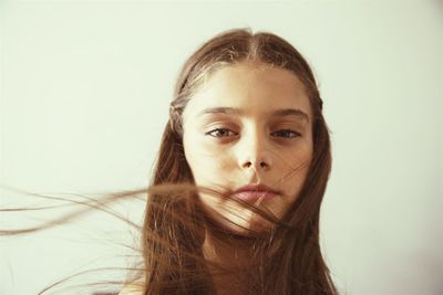 Portrait of young woman against white background