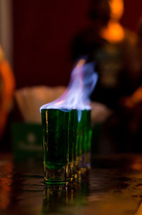 Close-up of fire on glass at table