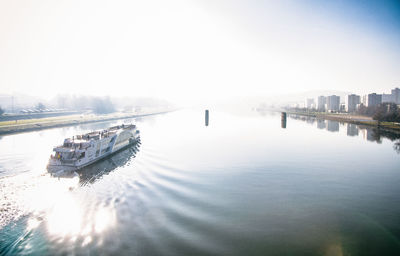 Bridge over river in city against sky