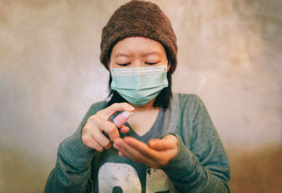 Girl with mask applying sanitizer