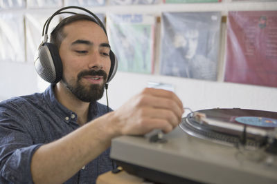 Young man listening to a record at a record store