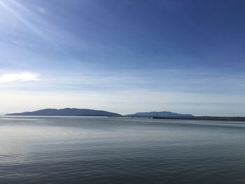 Scenic view of lake and mountains against blue sky