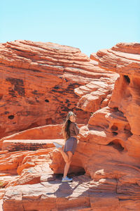 Rear view of woman standing on rock formations