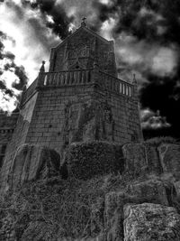 Low angle view of built structure against cloudy sky