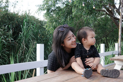 An asian mom hug her baby from behind