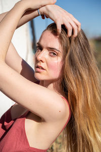 Portrait of young woman with arms raised