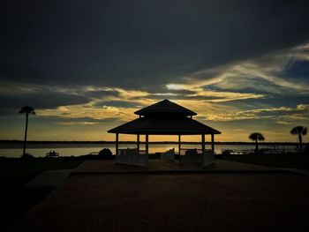 Silhouette of lifeguard hut on beach during sunset