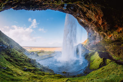 Scenic view of waterfall against sky