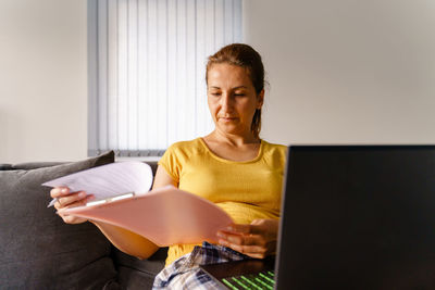 Young woman using mobile phone at home