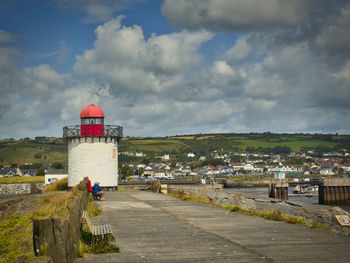 Lighthouse amidst buildings against sky