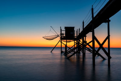 Typical  wooden fishing huts on stilts called carrelet  in the atlantic ocean near at sunset