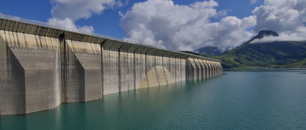 Panoramic view of roseland dam by lake against sky in french alpes 