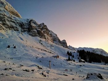 Scenic view of snow covered mountains against sky after sunset