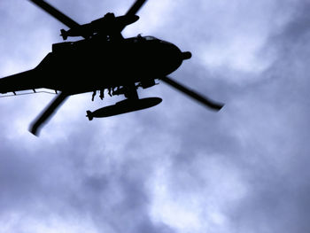 Low angle view of silhouette airplane against sky