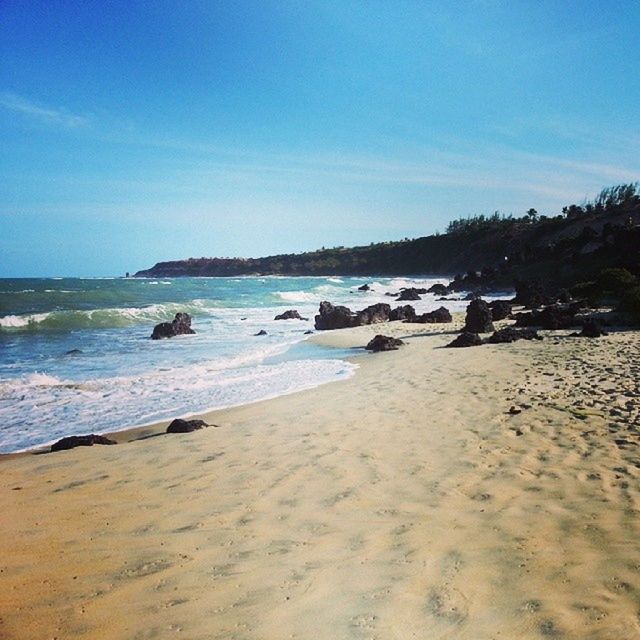 beach, sand, sea, water, shore, tranquil scene, tranquility, scenics, sky, beauty in nature, blue, coastline, nature, horizon over water, wave, idyllic, incidental people, surf, sunlight, day