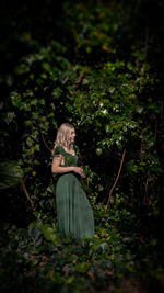 Rear view of woman standing amidst plants
