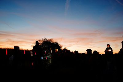 Silhouette people against sky during sunset